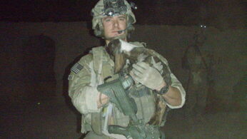 Ryan McCune in Army fatigues with a baby goat